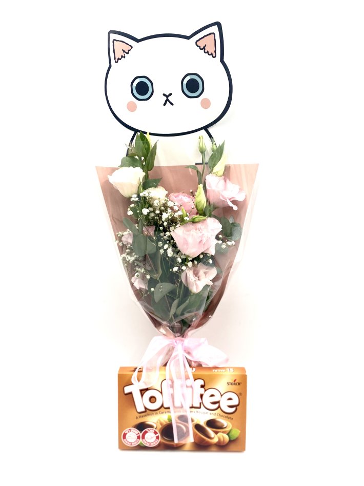 זר פרחים ורודים ולבנים עטוף בסרט ורוד, מלווה בקופסת שוקולד Toffifee ועיטור בצורת פנים של חתול חמוד
