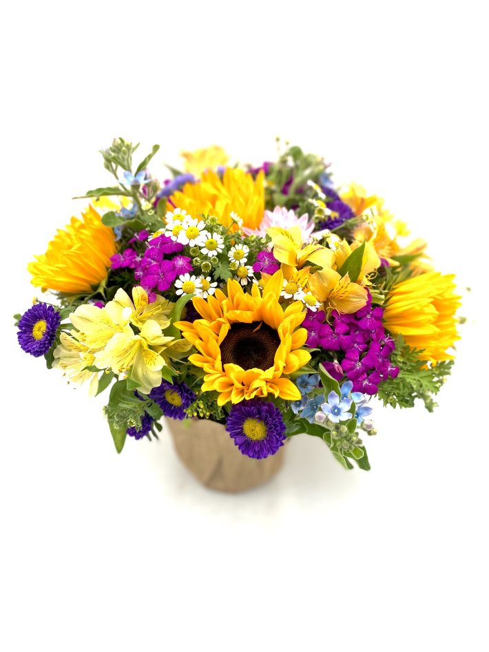 זר פרחים צבעוני הכולל חמניות, פרחים צהובים, סגולים, לבנים וכחולים בעיצוב טבעי ומרהיב