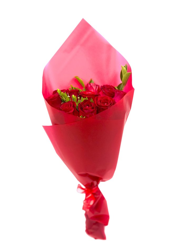 זר ורדים אדומים מרהיבים עטוף בנייר אדום מסוגנן, עם תוספת עלים ירוקים לעיצוב רומנטי ומיוחד